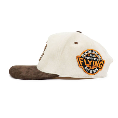 HeightsDistrict PR Suede Varsity Snapback hat with adjustable snap closure and embroidered logo on front, in navy and cream colors.