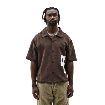 Black Island Brown top, a stylish black and brown women's blouse with a relaxed fit, displayed on a hanger.