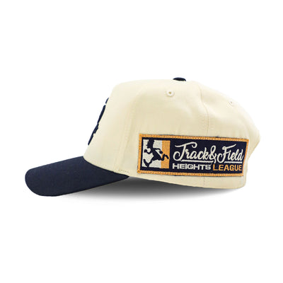Navy PR Varsity Snapback hat with HeightsDistrict logo on front, shown from left side view.
